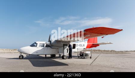 Helgoland, Germania. 25th Mar 2022. Presso il campo aereo di Helgoland è parcheggiato un'Islander normanna Britten con nove posti a sedere dell'Ostfriesischer Flug-Dienst (OFD). Il nuovo collegamento aereo da Helgoland a Uetersen (distretto di Pinneberg) inizia venerdì 1 aprile. Gli aerei di Ostfriesischer Flug-Dienst (OFD) sono previsti per il decollo da Helgoland Dune il mercoledì alla domenica con due rotazioni al giorno, come annunciato dalla società a Emden. Credit: Markus Scholz/dpa/Alamy Live News Foto Stock