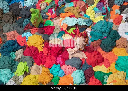 Narayanganj, Dhaka, Bangladesh. 29th Mar 2022. I lavoratori si smistano attraverso colorate pile di tessuti pronti per essere confezionati in abiti a Narayanganj, Bangladesh. I lavoratori selezionano e smistano i tessuti in base al colore, alla qualità e alla domanda degli acquirenti. I tessuti sono generalmente utilizzati nel processo di fabbricazione dell'abbigliamento. Sono impilati per la selezione e la classificazione così come per asciugare al sole con l'umidità che è rimossa dal processo di tintura. (Credit Image: © Joy Saha/ZUMA Press Wire) Foto Stock