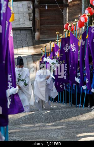 iida, nagano, giappone, 2022/24/03 , i sacerdoti Shinto salendo i gradini che portano al santuario di Omiya verso la fine della processione religiosa dove t Foto Stock