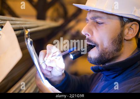 ispettore di costruzione maschile prendendo appunti Foto Stock