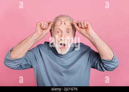 Foto di impressa funky ragazzo pensionato vestito grigio braccio pullover occhiali bocca aperta isolato rosa sfondo di colore Foto Stock