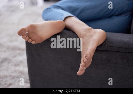 Im stare fuori dai miei piedi oggi. Scatto ritagliato di un piede femminile mentre si trova su un divano. Foto Stock