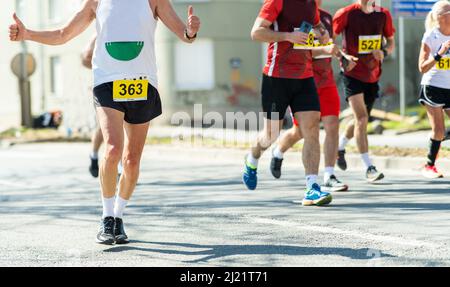 Maratona corsa, persone piedi su strada.Città ​​marathon Foto Stock