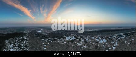 Veduta panoramica aerea panoramica sulla palude naturale primaverile con piscine ghiacciate e un'alba panoramica nel cielo Foto Stock