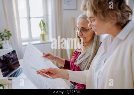 Le donne mature architetti che guardano i progetti insieme in ufficio . Foto Stock