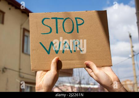 Mano che tiene Stop War scritto cartello. Manifestazione contro la guerra. Foto Stock