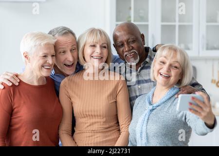 Cinque persone anziane allegre che prendono selfie sul telefono cellulare Foto Stock