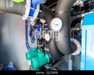 Interno industriale di pompa dell'acqua, valvole, manometri, motori all'interno del vano motore. Valvole e pompe in un locale industriale. Urban moderno e potente pi Foto Stock