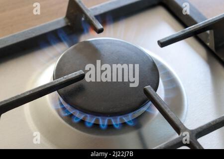 Il piano cottura a gas è acceso con fiamma blu Foto Stock