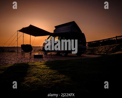 Tramonto sulle South Downs presso la Bow Hill Farm. Regno Unito campeggio Vanlife con un VW T5 camper furgone e tenda. Foto Stock