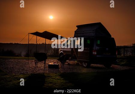 Tramonto sulle South Downs presso la Bow Hill Farm. Regno Unito campeggio Vanlife con un VW T5 camper furgone e tenda. Foto Stock