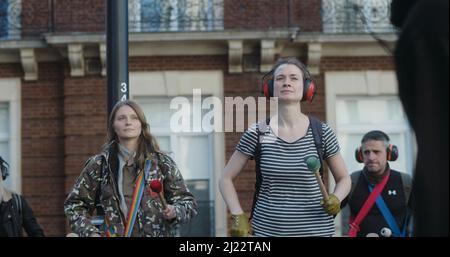 Londra, UK - 03 19 2022: Gruppo di estinzione Rebellion clima protesta percussionisti suonare tamburi, a Portland Place. Foto Stock