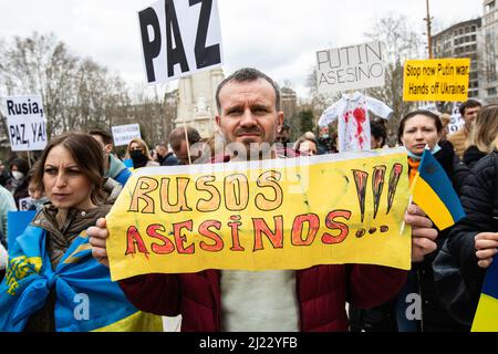 Un uomo ha un segno che dice 'Killer Russians' durante una protesta contro la guerra in Ucraina a Madrid, Spagna Foto Stock