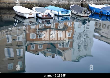 Vecchia barca in legno nel fiume. Uno sguardo vicino di vecchia barca di pesca di legno che galleggia sul piccolo fiume, riflessione dell'edificio. Momento Magneficient e anche drammatico. Foto Stock