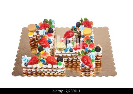 Torta di compleanno creativa fatta di numeri quattordici di frutta, bacche e macaroon su sfondo bianco. Primo piano dall'alto. Foto Stock