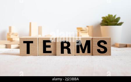 I termini firmano in un ufficio luminoso su una scrivania di legno con le finestre sullo sfondo. Foto Stock