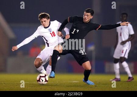 Leighton Clarkson (a sinistra) in Inghilterra e Lazar Samardzic in Germania combattono per la palla durante la partita Under 20 Elite League al JobServe Community Stadium di Colchester. Data foto: Martedì 29 marzo 2022. Foto Stock