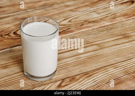 Bicchiere di latte fresco su tavola di legno. Foto Stock