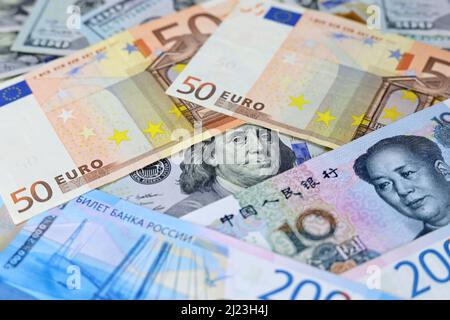 Dollari USA, yuan cinese, banconote in euro e rubli russi. Concetto di guerra commerciale tra Cina e Stati Uniti, sanzioni americane ed europee Foto Stock