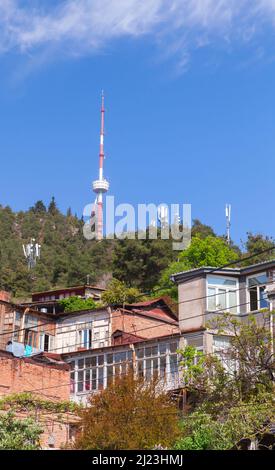 Georgia, vecchia Tbilisi vista strada con case e TV Broadcasting Tower in una giornata di sole Foto Stock
