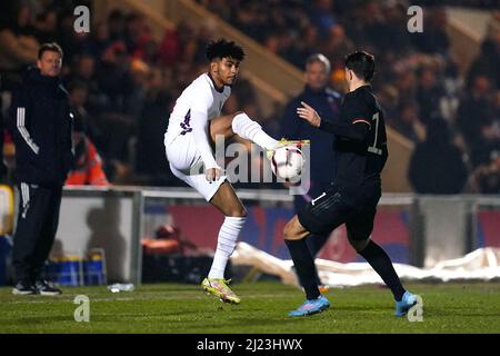 Kaine Kesler-Hayden in Inghilterra e Lazar Samardzic in Germania (a destra) lottano per la palla durante la partita Under 20 Elite League al JobServe Community Stadium di Colchester. Data foto: Martedì 29 marzo 2022. Foto Stock