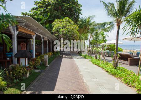 Vista sul sentiero di Sanur Beach e sulla Starfish Beach Lounge presso il Griya Santrian Hotel a Sanur, Bali, Indonesia. Foto Stock