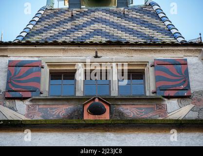 Zug, Svizzera - 31 dicembre 2021: Vista ravvicinata sulla torre medievale con vecchie finestre e colorate tegole in cima Foto Stock