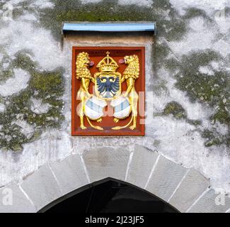 Zug, Svizzera - 31 dicembre 2021: Un antico arco medievale sopra la strada della città con stemmi sopra Foto Stock