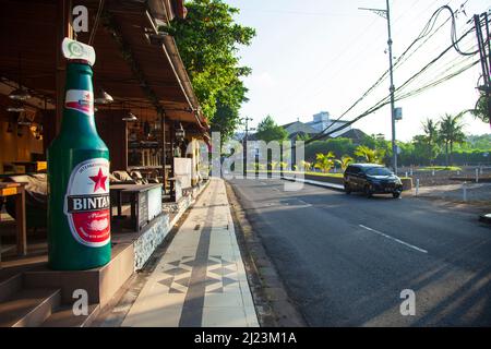 Jalan Kartika Plaza a Kuta, Bali, con la sua famosa bottiglia di birra KaBar Grill Bintang sulla sinistra. Foto Stock