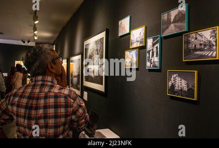 New Delhi, India. 29th Mar 2022. Un visitatore guarda un muro di foto incorniciate durante un'anteprima della mostra fotografica, 'Ucraina Untold (scorcio)' memorie da un fotografo di viaggio, Avantika Meble a Open Palm Court, India Habitat Center, Nuova Delhi. Credit: SOPA Images Limited/Alamy Live News Foto Stock