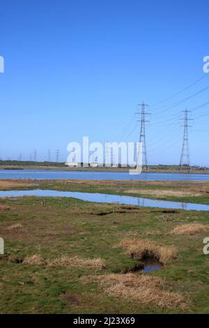 Linee elettriche e piloni nazionali di trasmissione dell'elettricità attraverso il fiume Lune a Stodday vicino Lancaster con l'alta marea nel fiume. Foto Stock