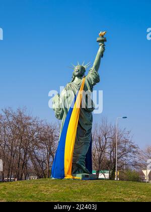 Colmar, Francia - 29 marzo 2022: Copia della Statua della libertà, progettata da Frederic Auguste Bartholdi. Statua avvolta con la bandiera Ucraina in giallo A. Foto Stock