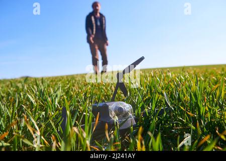 scioccato uomo con drone rotto. Uomo preoccupato con gadget crash. Giovane eccitato (uomo deluso) con drone che cade sul campo. Selezione f Foto Stock