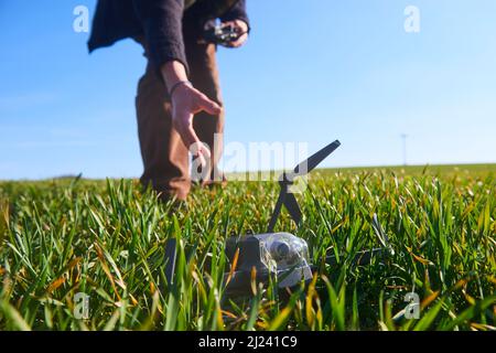 scioccato uomo con drone rotto. Uomo preoccupato con gadget crash. Giovane eccitato (uomo deluso) con drone che cade sul campo. Selezione f Foto Stock