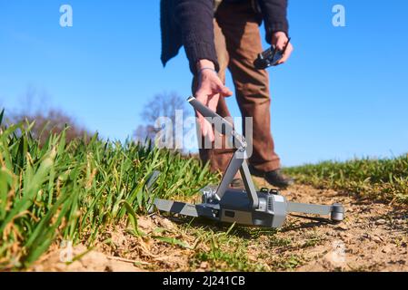 scioccato uomo con drone rotto. Uomo preoccupato con gadget crash. Giovane eccitato (uomo deluso) con drone che cade sul campo. Selezione f Foto Stock