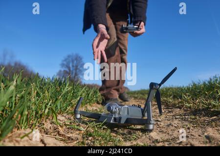 scioccato uomo con drone rotto. Uomo preoccupato con gadget crash. Giovane eccitato (uomo deluso) con drone che cade sul campo. Selezione f Foto Stock