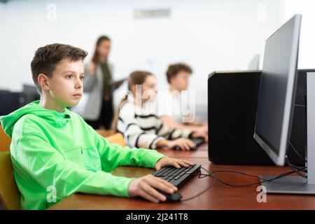 Ragazzi di età presteen che imparano i principi fondamentali della programmazione in college di calcolatore Foto Stock