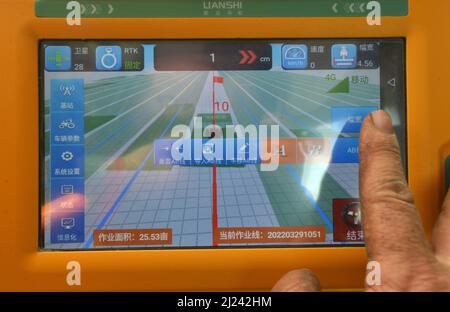 BAZHOU, CINA - 29 MARZO 2022 - Un operatore di telefonia mobile regola un sistema di navigazione in un campo di cotone a Bazhou, provincia di Xinjiang, Cina, 29 marzo 2022. Foto Stock