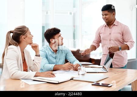 Ive ha ricevuto alcune notizie. Scatto corto di tre giovani colleghi di lavoro che lavorano insieme nella sala riunioni. Foto Stock