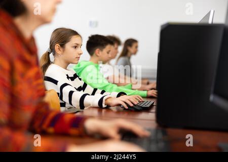 Ragazza adolescente messa a fuoco che studia nel laboratorio di calcolatore dell'università Foto Stock