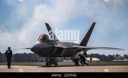 Un manutentore con il team dimostrativo F-22 Raptor prepara un F-22 prima del decollo alla base dell'aeronautica di MacDill, Florida, 27 marzo 2022. Il team dimostrativo si è esibito durante il Tampa Bay Airfest 2022, dove la comunità locale ha assistito alla combinazione di furtività, supercrociera, manovrabilità e avionica integrata della F-22. (STATI UNITI Air Force foto di Airman 1st Classe Joshua Hastings) Foto Stock