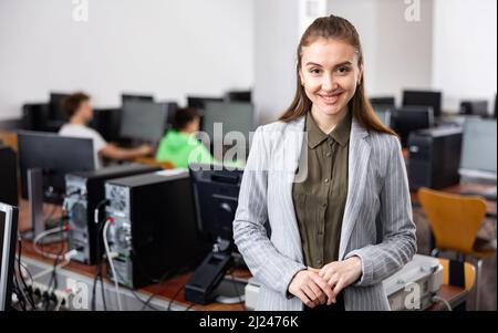 Ritratto di giovane donna sorridente insegnante di classe informatica a scuola Foto Stock