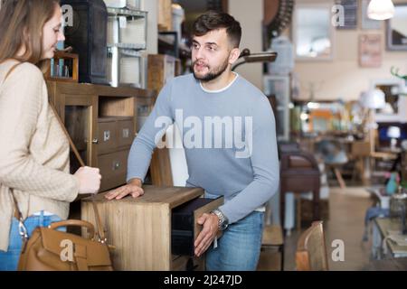 Uomo con moglie alla ricerca di un piccolo armadio in negozio Foto Stock