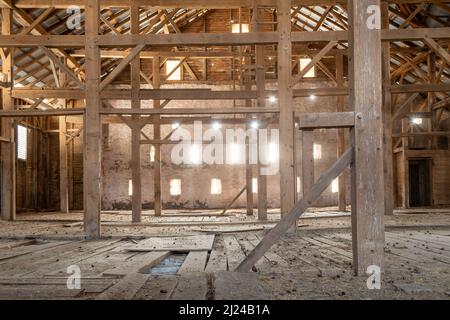 Vecchio granaio travi di legno di luce solare interno polveroso Fattoria vuoto Foto Stock