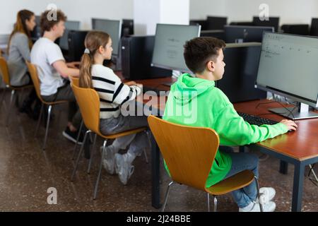 Bambini che usano i computer durante la lezione di informatica Foto Stock