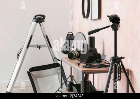 Moderno impianto di illuminazione vicino alla parete rosa in studio fotografico Foto Stock