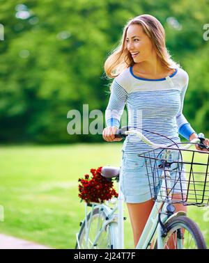 Escursioni in bicicletta in campagna. Sparato di una giovane donna in bicicletta nel parco. Foto Stock