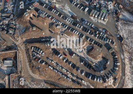 File di auto in piedi al mercato auto girato dall'alto. Vendita di auto usate portate dal Giappone. Foto Stock