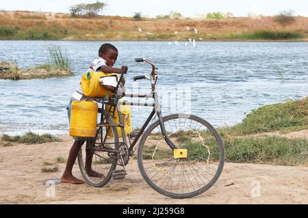 (220330) -- KILIFI, 30 marzo 2022 (Xinhua) -- Un ragazzo carica un secchio d'acqua su una bicicletta nella sub-locazione di Kidemu nella contea di Kilifi, Kenya, 23 marzo 2022. Sparsi sulla fattoria di cinque acri nel villaggio di Bandari, la sotto-posizione di Kidemu nella contea costiera Kilifi del Kenya, erano raccolti di mais appassiti. Adam Ndamunga, un ufficiale della NDMA (NDMA) del Kenya a Kilifi, ha detto che la situazione di siccità nella regione è iniziata nell'agosto 2021 ed è in corso a causa delle piogge inadeguate. L'agenzia di soccorso delle Nazioni Unite ha dichiarato che il Corno d'Africa sta vivendo una delle peggiori siccità Foto Stock