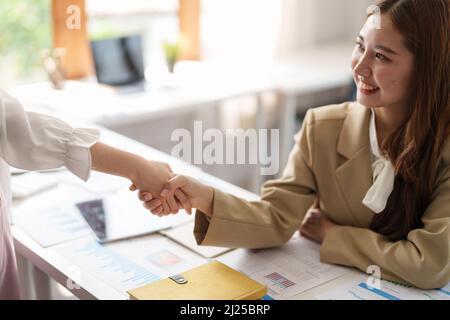 Fidata donna d'affari che agita le mani durante una riunione nell'ufficio, successo, trattando, saluto e concetto del socio Foto Stock